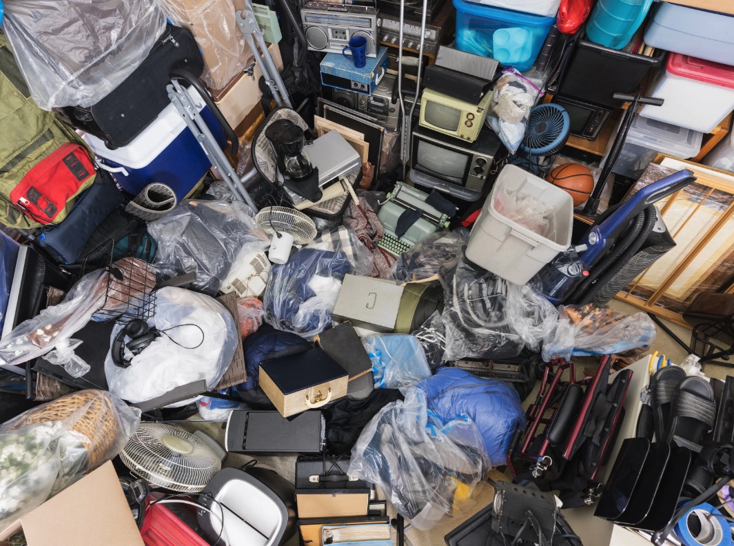 Dense room with mixed boxes and belongings before a Clawson hoarding cleanout