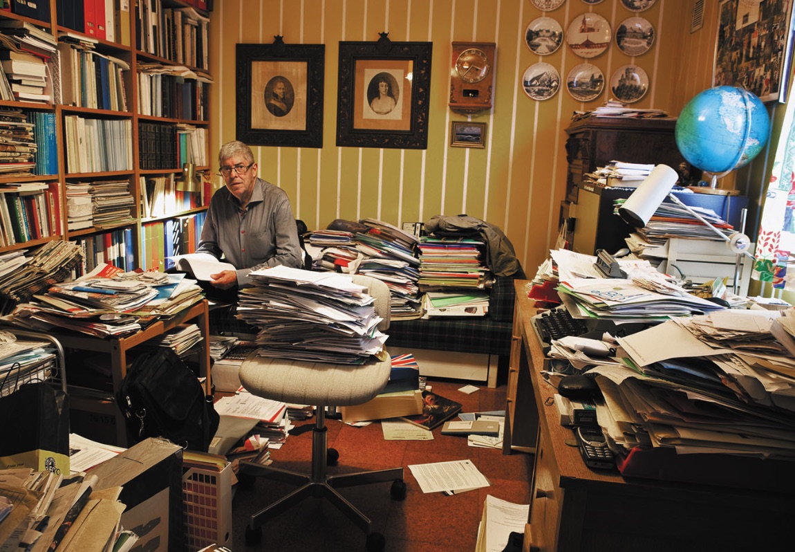 Clawson room with stacked boxes and household clutter before cleanup
